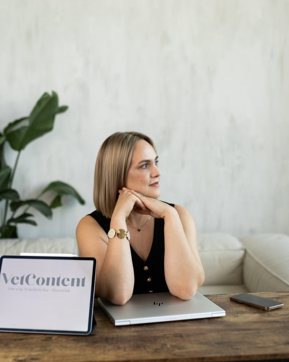 Patrycja przy biurku z tabletem z logo VetContent